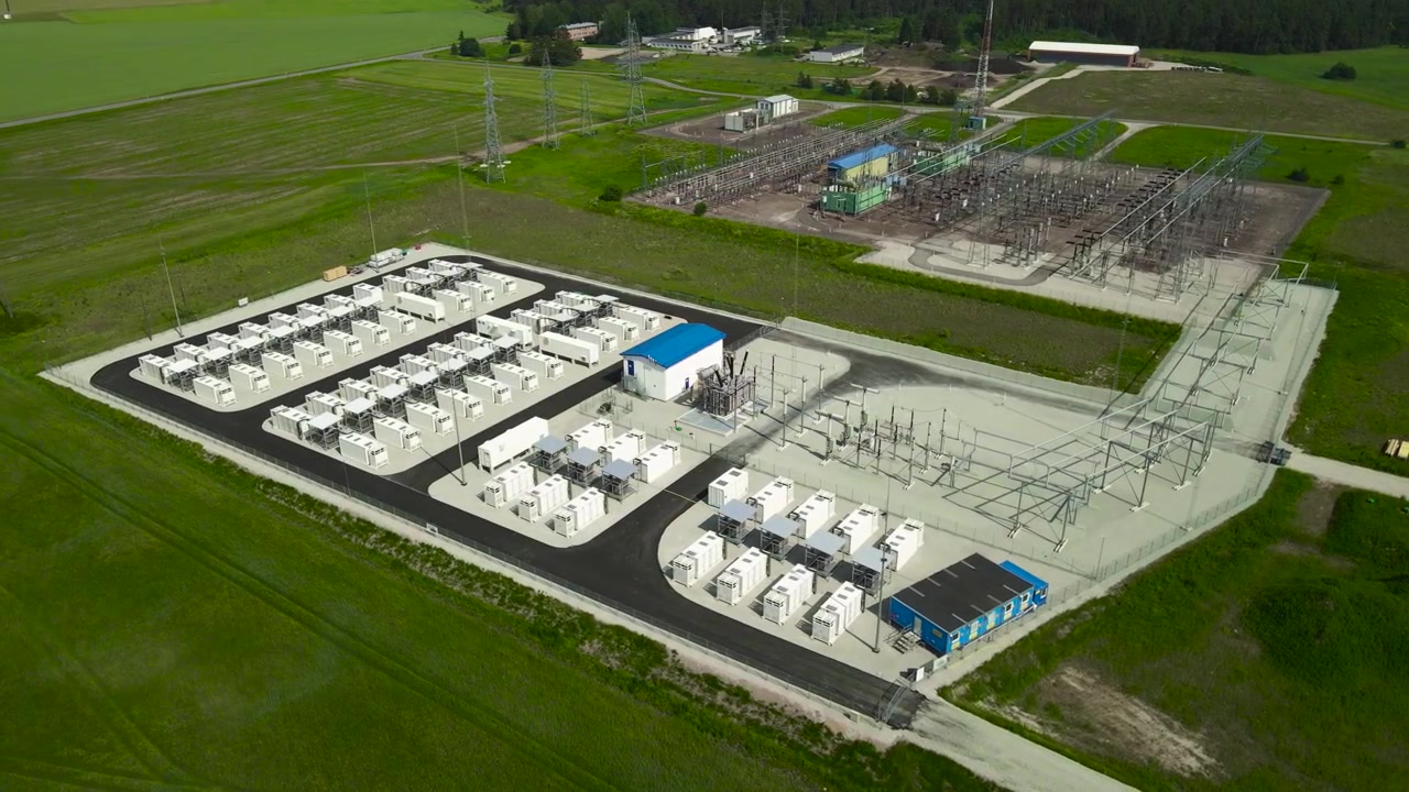 Moderní bateriové úložiště energie s kontejnerovými moduly pro obnovitelnou energii a vysokonapěťovou elektrickou rozvodnu, představující infrastrukturu čisté energie pro udržitelnou budoucnost.