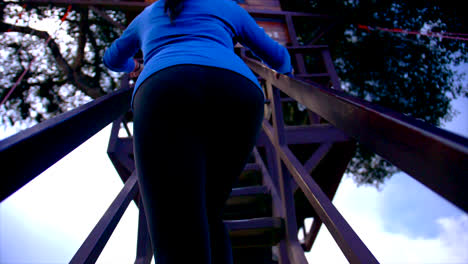woman in blue clothes climbing the stairs