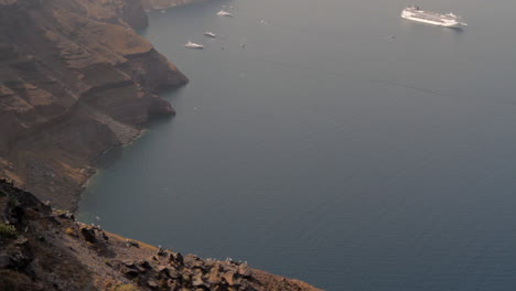 seagulls hover the majestic seascape of santorini with a cruise ship in the background