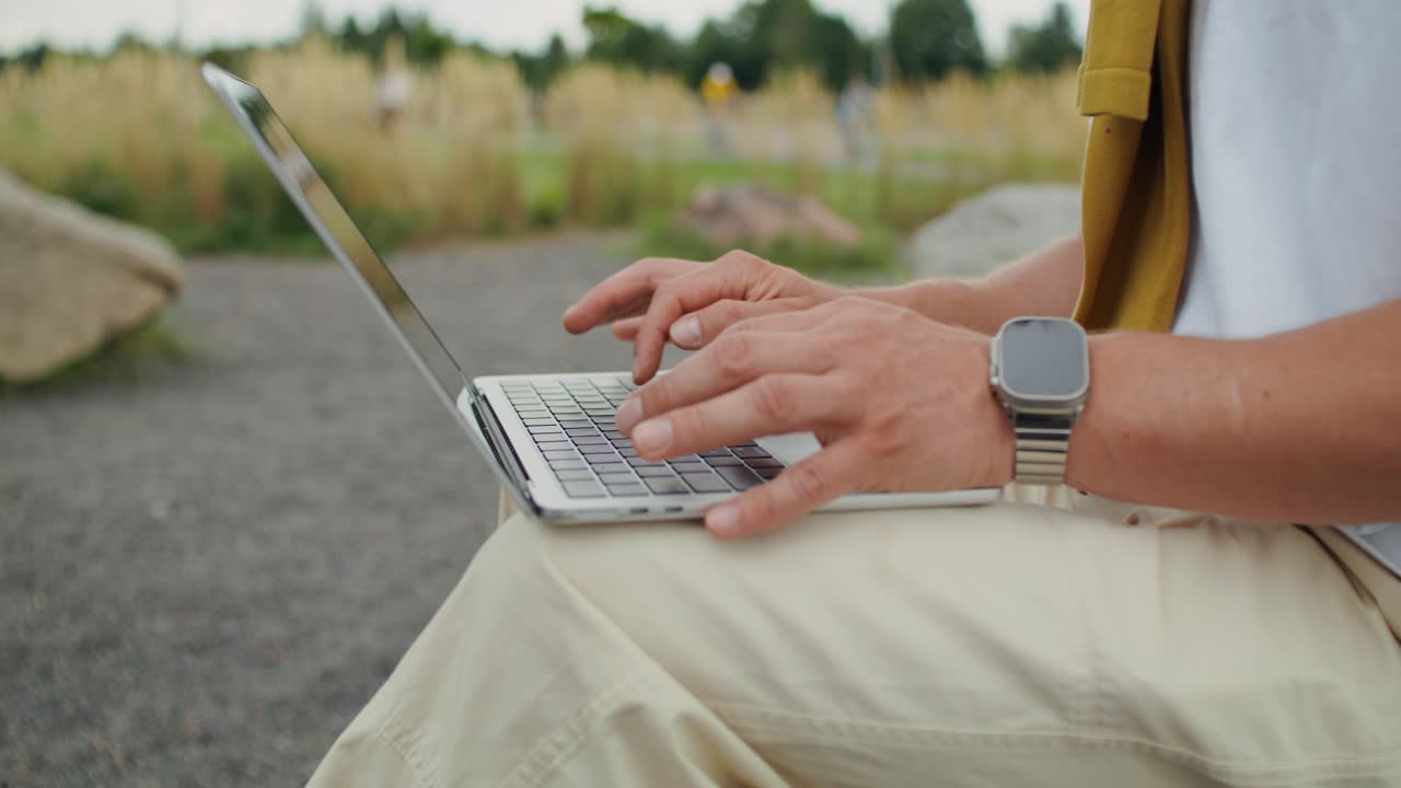 Man working on laptop outdoors