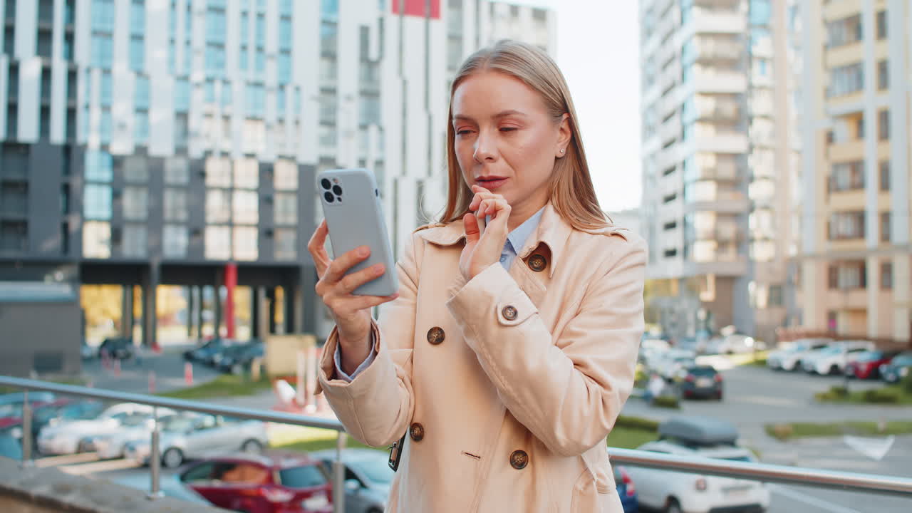 Upset businesswoman using smartphone browsing loses becoming shocked bad news on downtown street