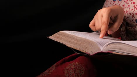 muslim women's hand reading quran at night