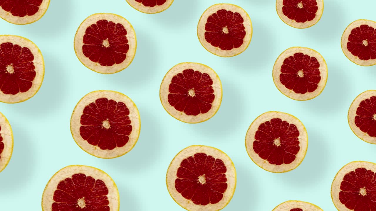 Colorful pattern of fresh grapefruits. Top view. Seamless pattern with grapefruit sliced. Pop art design. Realistic animation. 4K video motion