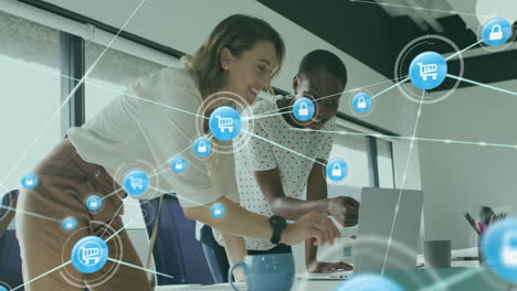 animación de iconos conectados sobre diversas compañeras de trabajo de pie y discutiendo informes en la computadora portátil