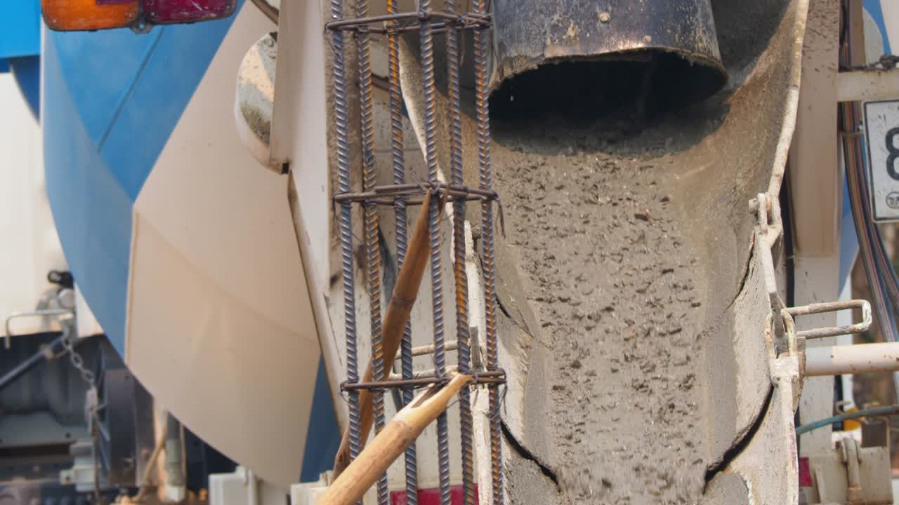 el flujo de hormigón que se vierte desde el camión mezclador vierte hormigón líquido en la fundación para el refuerzo del edificio. construcción de edificios y concepto de la industria. movimiento 4k b-roll imágenes