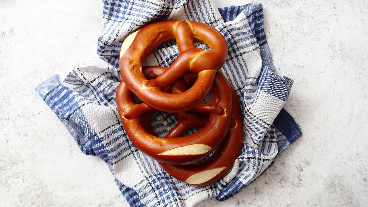 Três pães pretzel alemães recém-assados colocados em guardanapo.