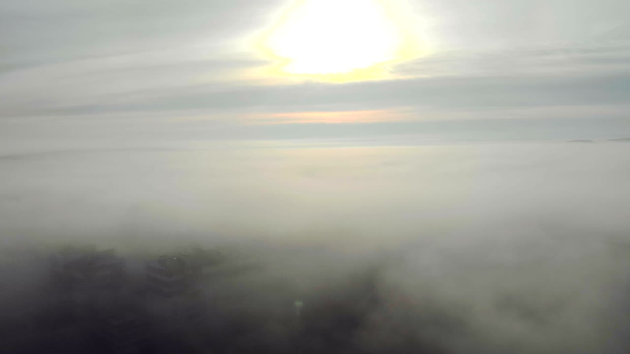 도시를 고 있는 거대한 안개로 카메라가 올라가서 도시 위에 놓인 안개의 파노라마를 보여준다.