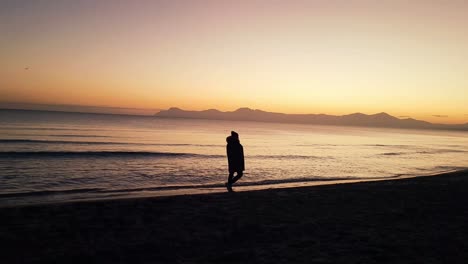 man walking at dawn on muro beach