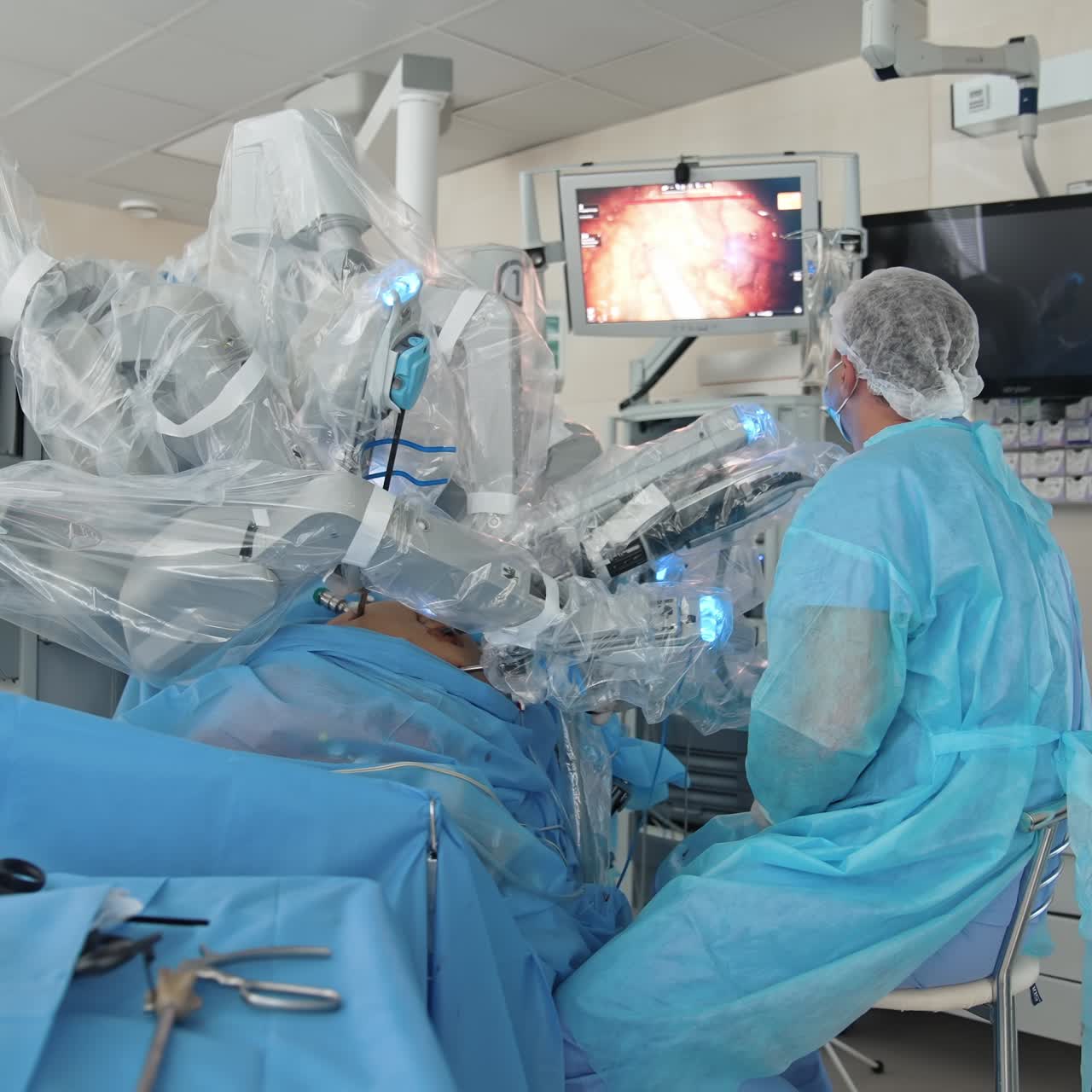 Futuristic robotic equipment in modern clinic. Doctor observes surgical process on medical monitor in the operating room