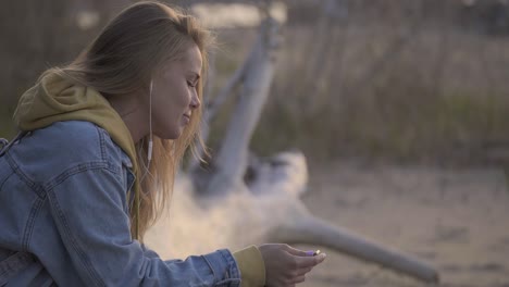 traveling girl sit on the beach and listen music