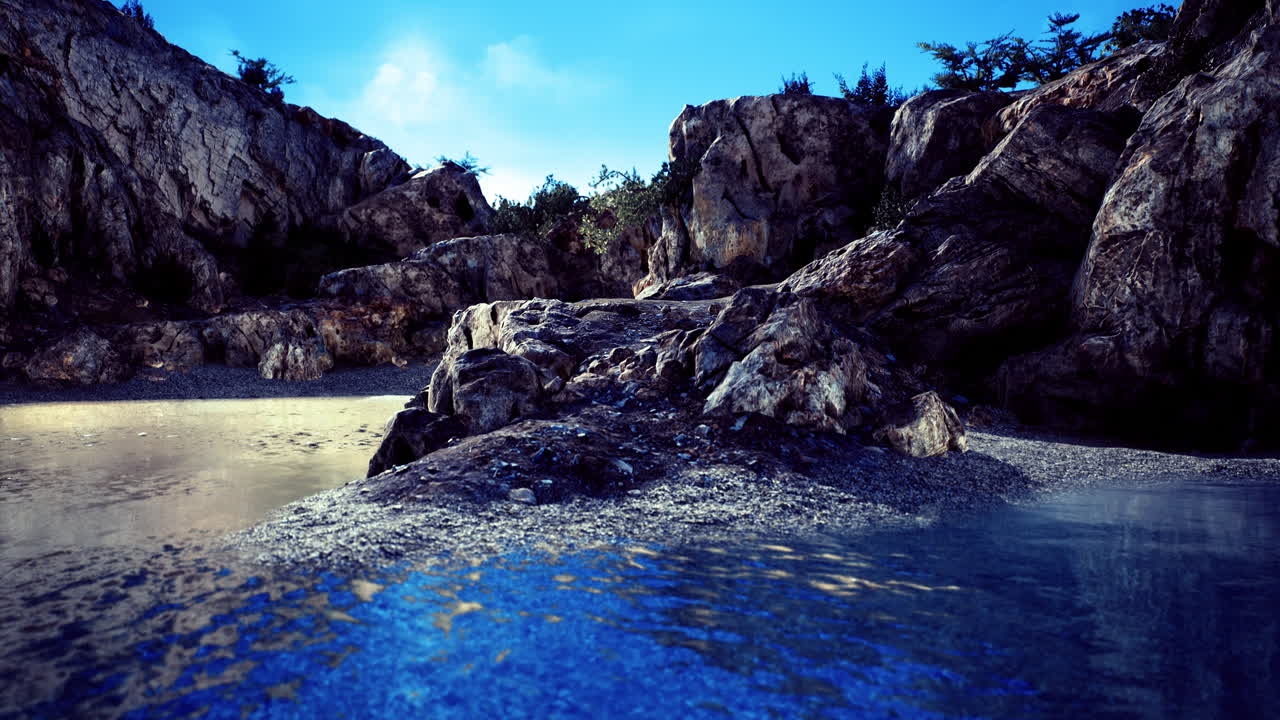 Sunlit rocky coastline with tranquil waters and vibrant blue skies at midday