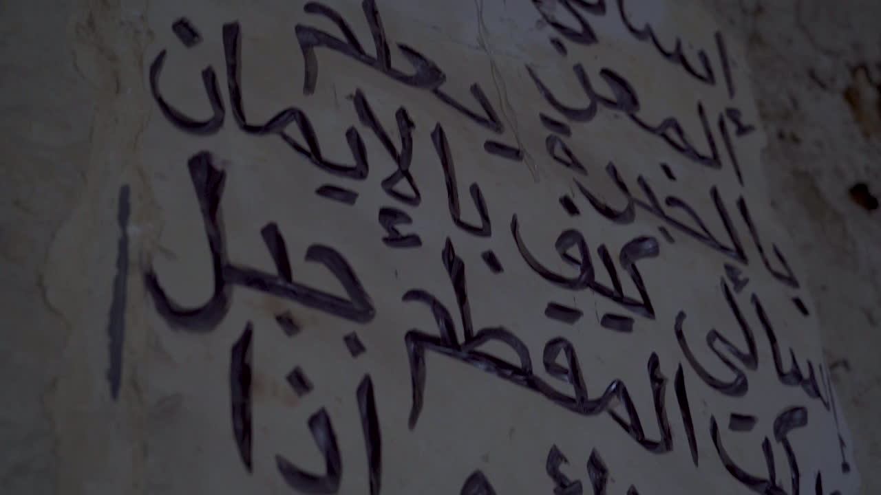 Words engraved on the wall in the place of an archaeological landmark in Egypt - a camera moving from up to down
