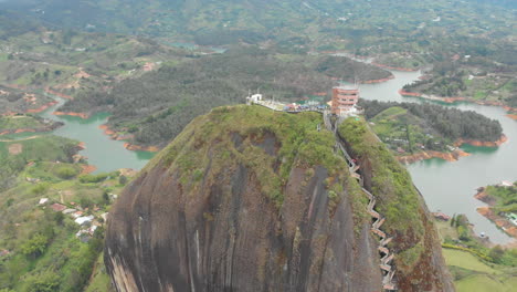 aerial view of piedra del peñol monolith big black stone in guatape, antioquia - colombia tourist site - drone shot