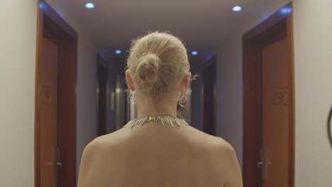 woman walking down a hotel corridor at night