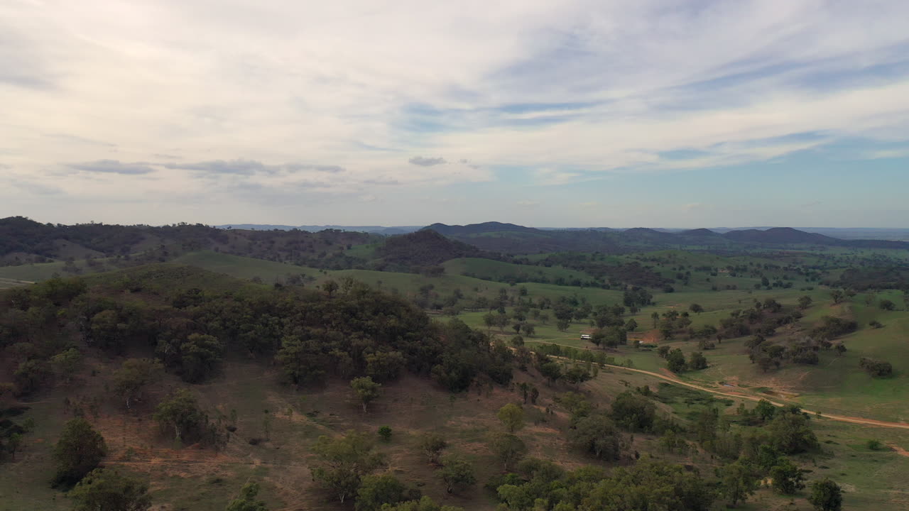 호주 뉴사우스웨일즈주 뉴사우스웨일즈 시골 풍경 머지에 있는 언덕과 나무 위로 날아가는 공중 와이드샷