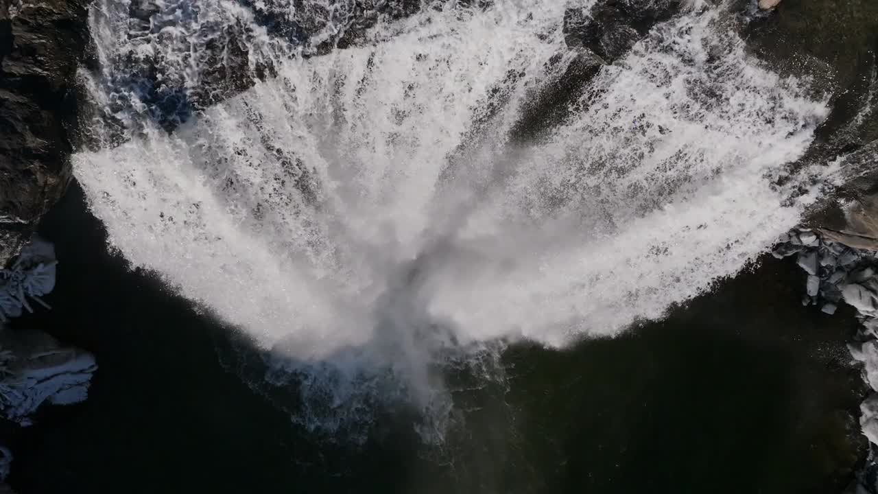 un dron aéreo captura la majestuosa cascada que cae en cascada por una montaña rocosa en islandia, con el agua fluyendo poderosamente sobre acantilados escarpados, creando un sorprendente contraste entre los elementos naturales