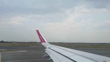 time lapse of wizz air plane wing in the international airport of vienna, flughafen wien-schwechat during the day 4k