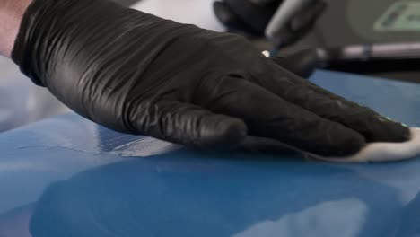 car detailing: applying wax to a blue car