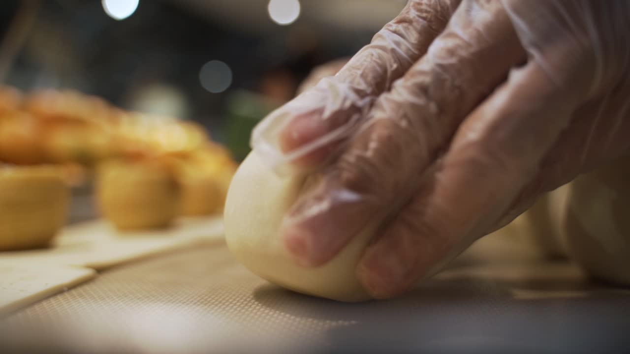 This is a shot of a chef wrapping an apple with puff pastry and the apple is filled with sugar and cinnamon.