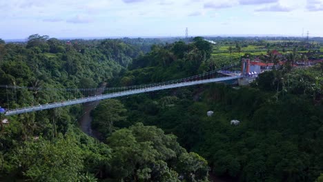 Breathtaking-view-of-Blangsingah-Glass-Bridge-over-a-river-valley-near-Tegenungan-Waterfall-in-Bali,-Indonesia