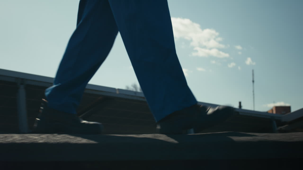 Worker Walking on Rooftop with Solar Panels