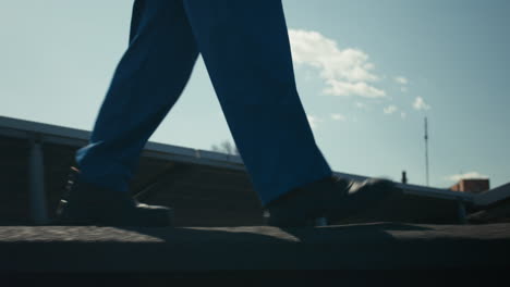 worker walking on rooftop with solar panels