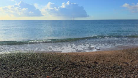 Playa-De-Arena-Y-Pequeñas-Piedras-En-Cámara-Lenta-Con-Pequeñas-Olas