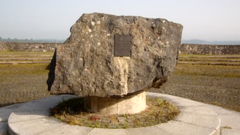 shot-of-decorative-opening-plaque-stone-sculpture-at-Carsington-Water-overgrown-viewing-area-with-the-Water-Valve-Tower,-Draw-Off-Tower-in-the-Background