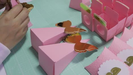woman's hands working on decorating candy boxes in studio