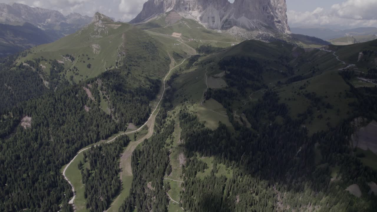 수평선에 sassolungo 산이 있는 셀라 패스 위로 설명적인 정면 비행기가 앞으로 이동하는 드론 비디오