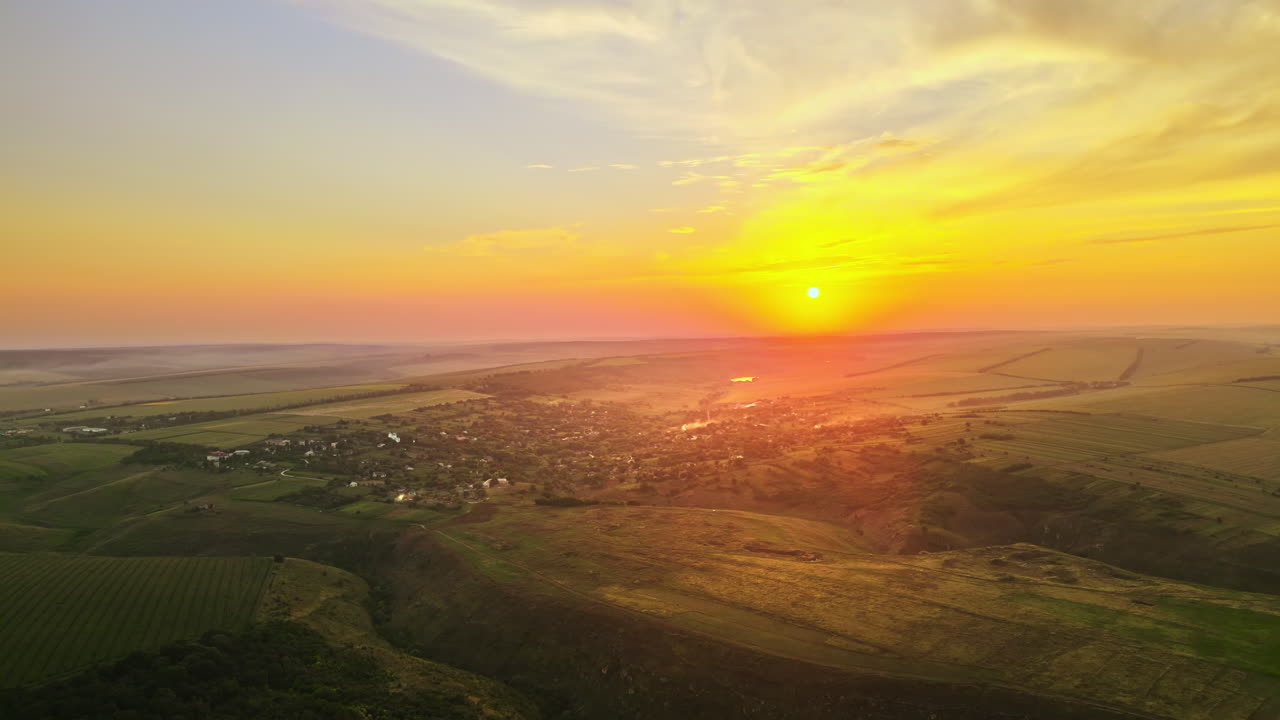 Aerial drone view of nature in Moldova at sunset. Village, sun, fields and hills