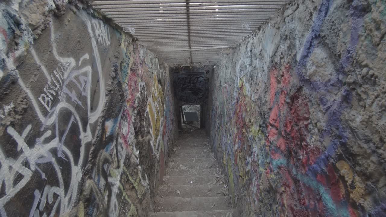 그래피티로 가득 찬 지하층 계단의 전망을 아래로 기울입니다.