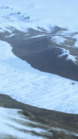 aerial view of snowy mountains and a glacier