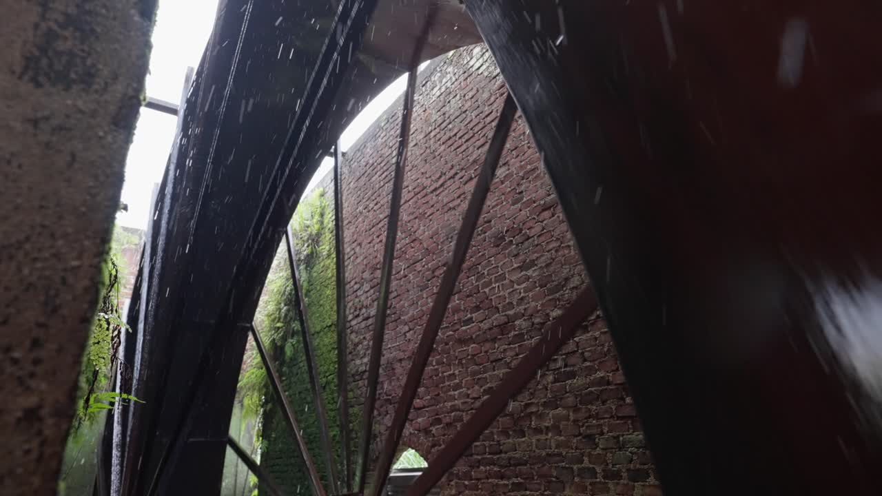 SLOW MOTION ULTRA WIDE SHOT OF A WATER MILL ON A SUGAR CANE PLANTATION IN MICHOACAN
