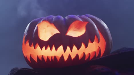 Video-of-halloween-carved-pumpkin-with-smoke-on-black-background