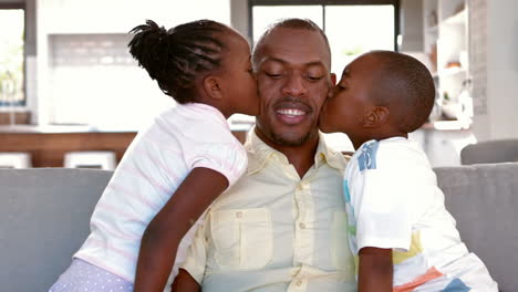 father and children sitting on couch