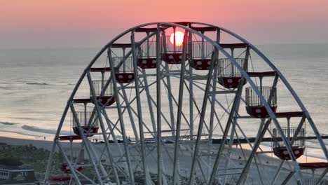 오션시티 (ocean city, nj) 의 화려한 일출, 원더랜드 피어 (wonderland pier) 의 페리스  (ferris wheel) 위에서 아오르고 있다.