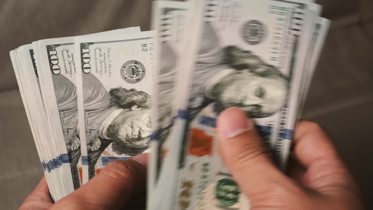 hombre de negocios contando billetes de dólares estadounidenses recién lanzados