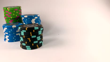 male hand moving a black stack of poker chips across the white table, isolated, slomo, still