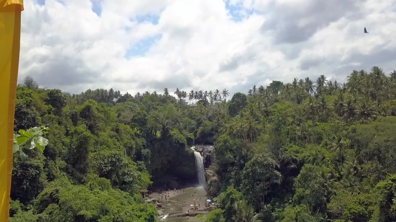 bandera amarilla frente a la cascada en la jungla