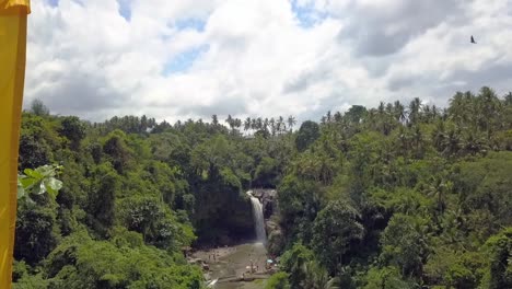 yellow flag in front of waterfall in jungle