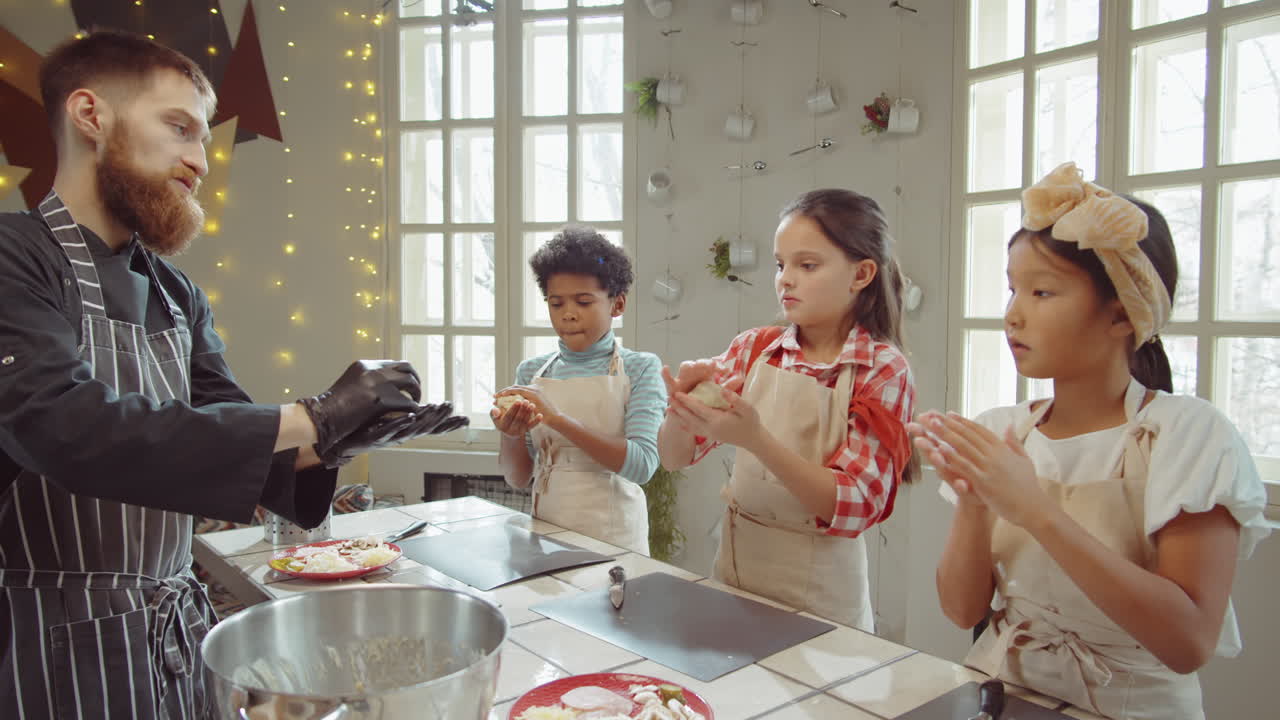 niños pequeños preparando masa con el chef en la clase magistral de cocina