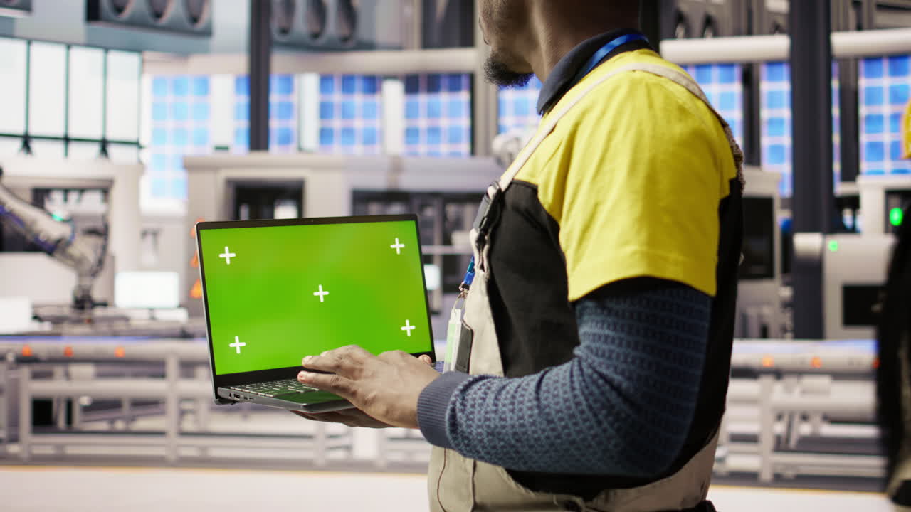 Vertical video Engineer oversees solar panel production lines equipment using mockup laptop