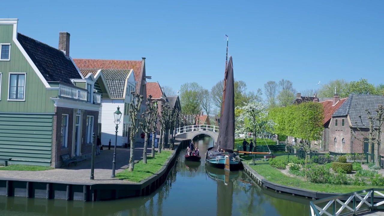 Scena di canale in un tradizionale villaggio olandese con barca e case storiche