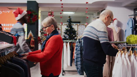 Octogenarian-clients-browsing-through-clothing-racks-in-festive-ornate-fashion-shop-during-winter-holiday-season.-Senior-couple-happy-after-finding-colorful-blazers-to-gift-at-Xmas-family-gathering