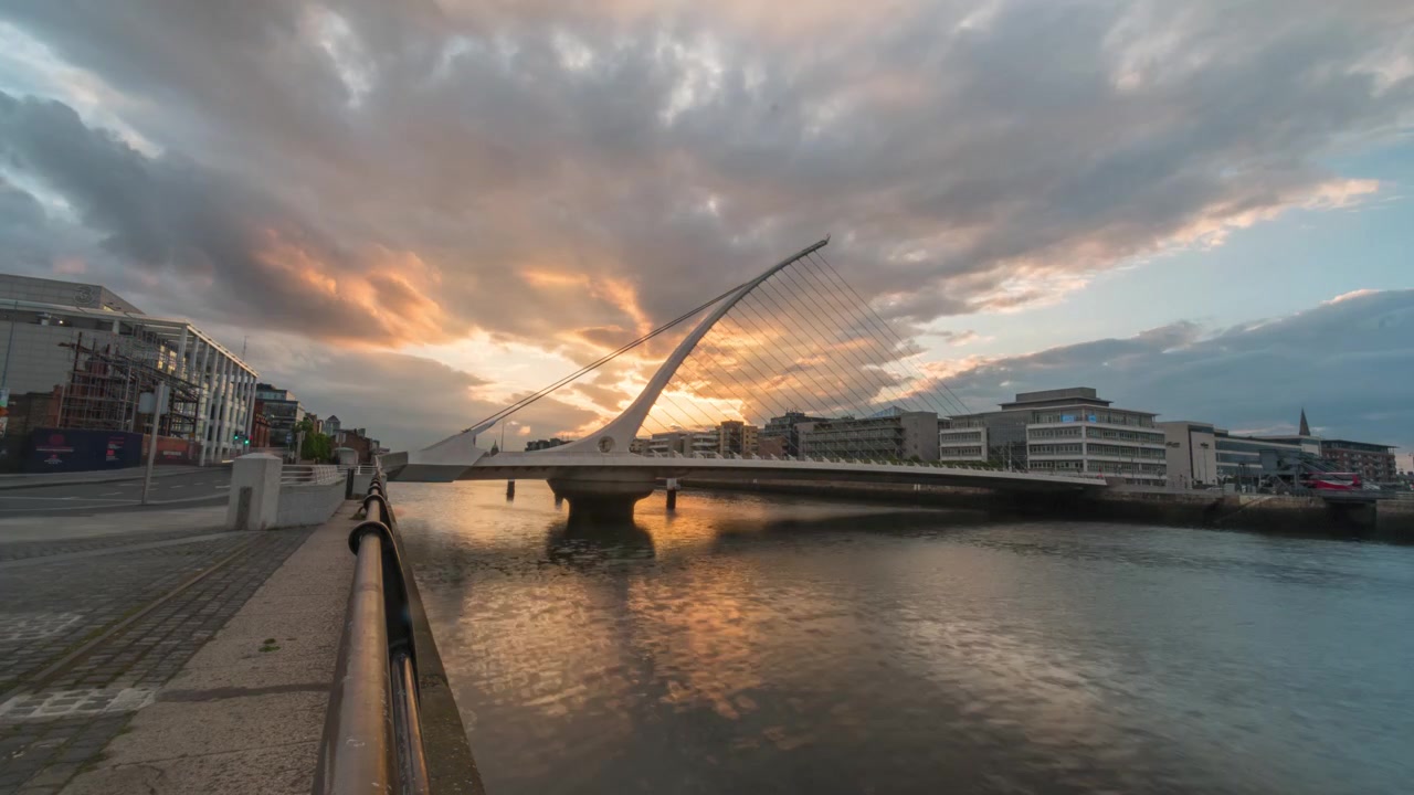 Timelapse dal giorno alla notte del Ponte Samuel Beckett sul fiume Liffey, con il sole che tramonta dietro il suo pilone a forma di arpa
