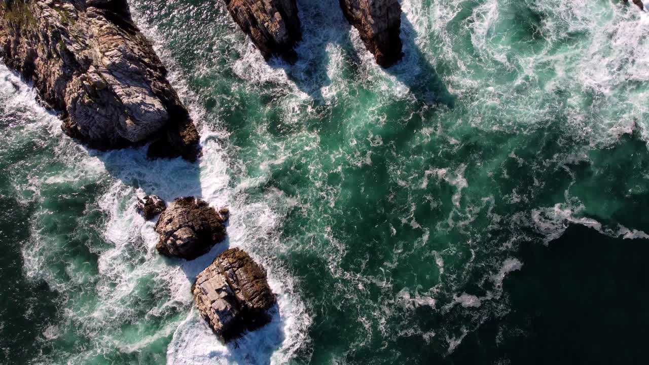 Vista dall'alto a volo d'uccello di onde oceaniche naturali e formazione rocciosa a scogliera, concetto ambientale Madre Terra