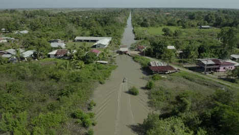 barco de vapor navegando en un canal lineal en medio de un verde paisaje rural.