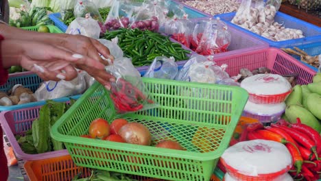 woman choosing vegetables in a traditional street market,thailand - close up