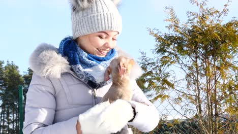 woman playing with her little dog outside winter